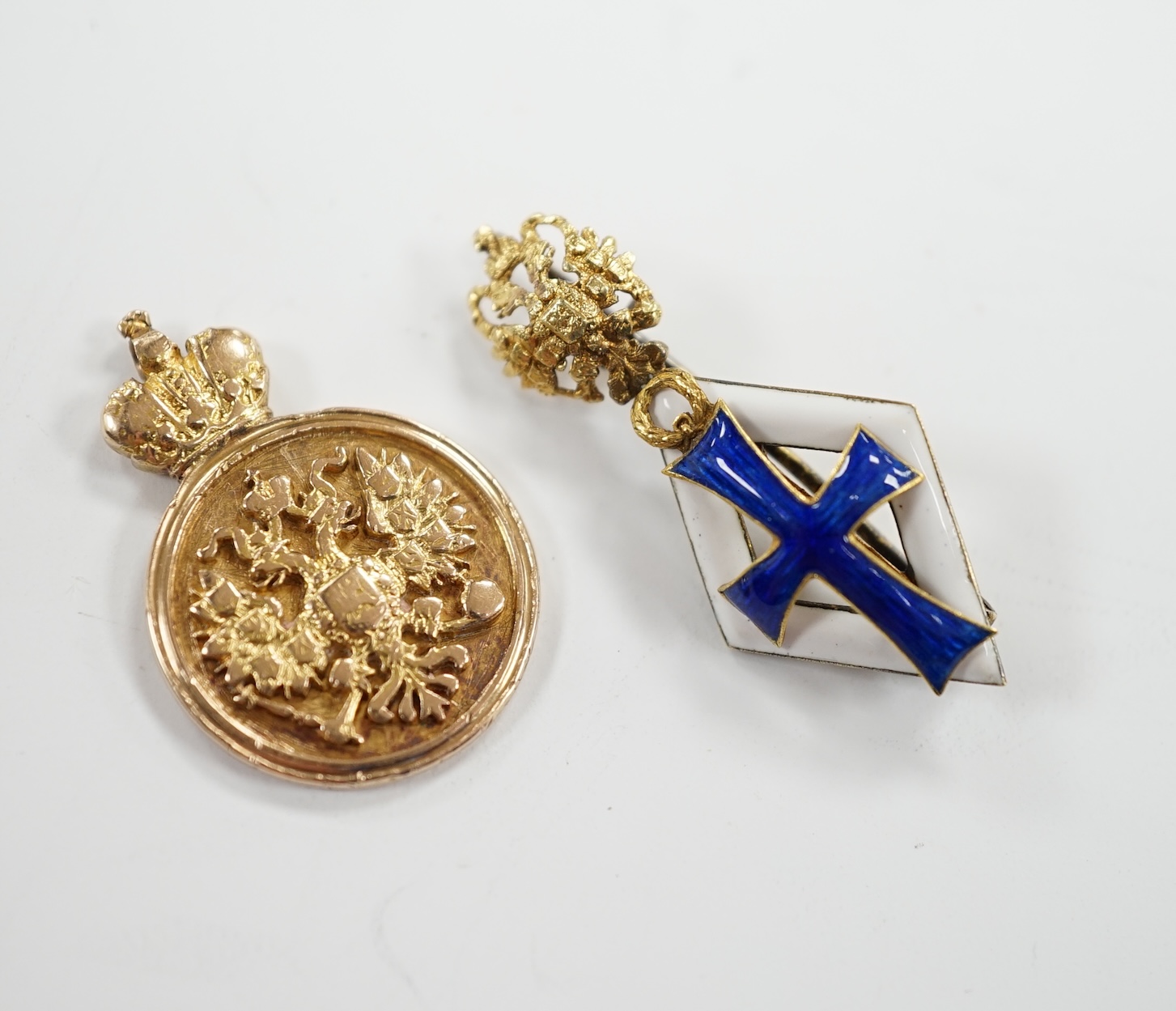 A Russian gilt white metal and enamel graduation from University of St Petersburg badge, 33mm and a yellow metal (tests as 14k) token for University Graduates, 5.1 grams.